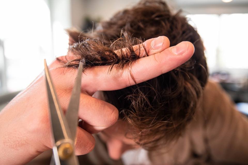 Scissors cutting a section of brown hair