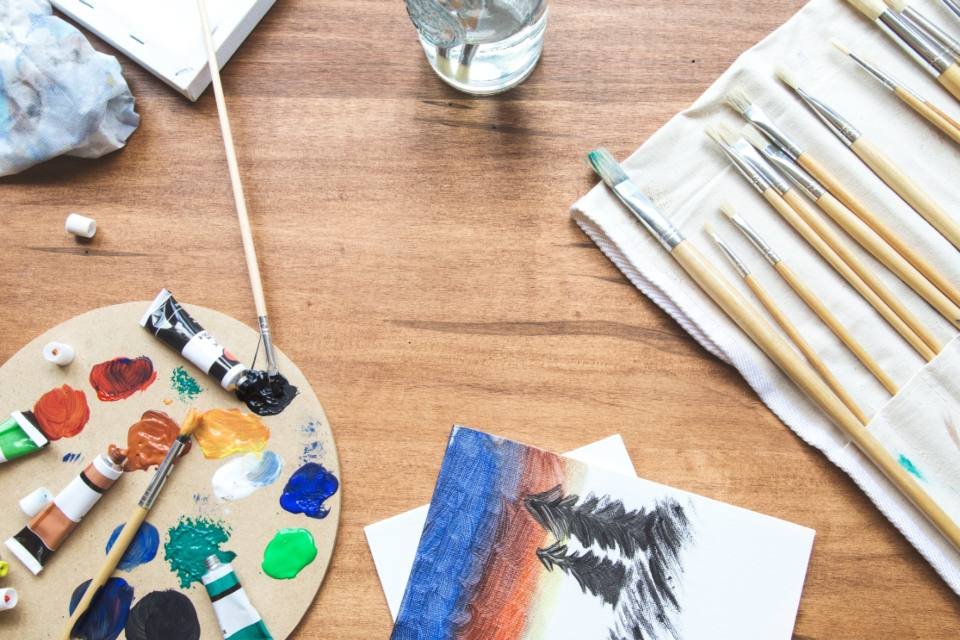 An artist's table with paints and brushes