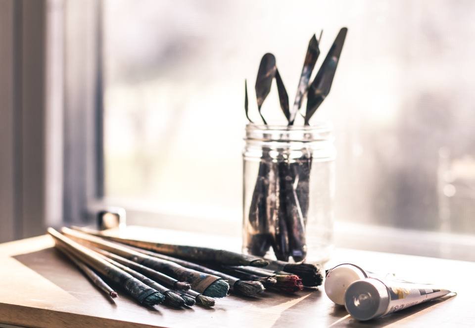 Paint brushes in a jar by a window