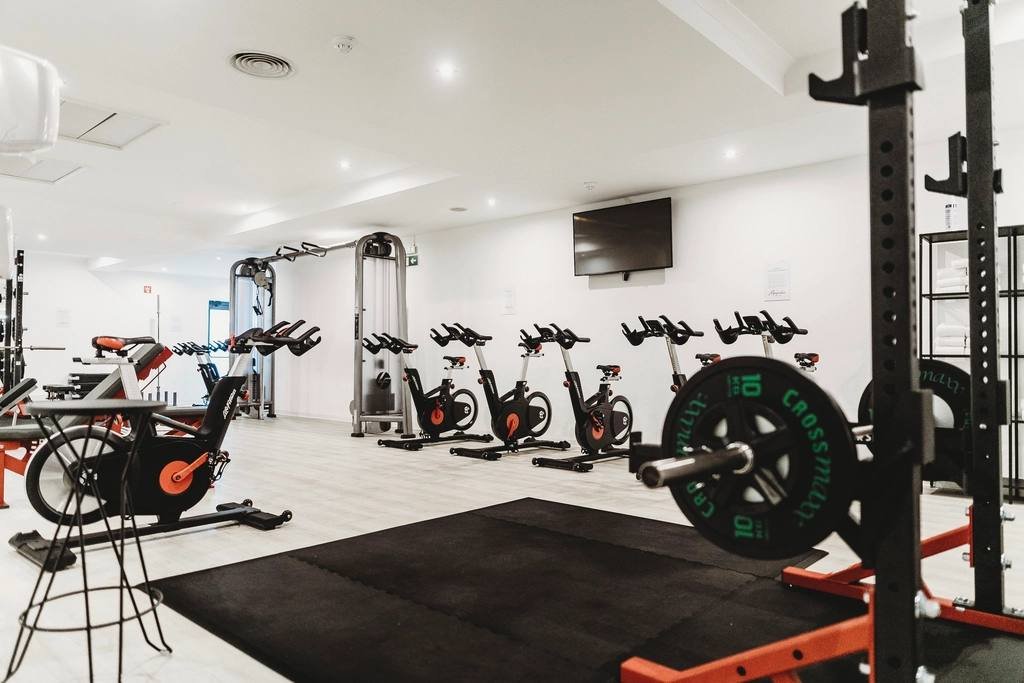 A bright gym with bikes, racks and weights