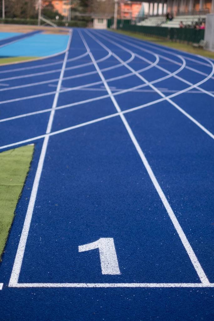 A blue running track, lane one