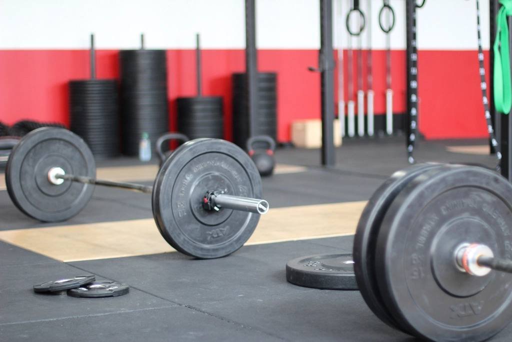A weight room with barbells and a red wall