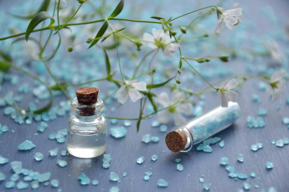 Small bottles of essential oil with white flowers
