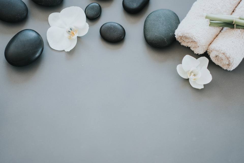 Smooth black spa stones with white orchids
