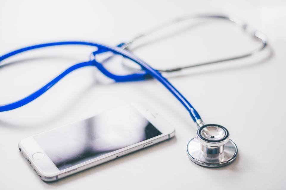 A stethoscope and a phone on a white desk
