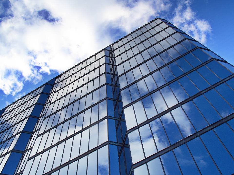 A glass tower against a cloudy sky