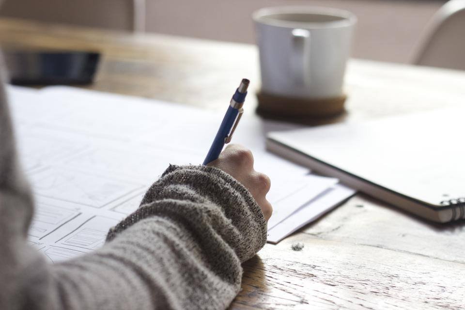 Someone writing notes at a desk