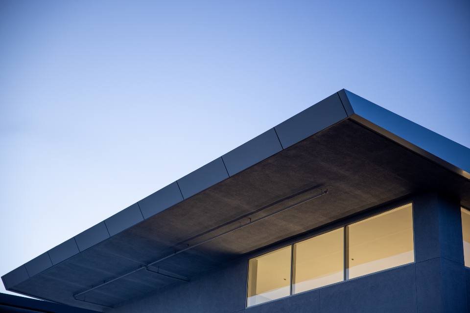 A modern house roofline against a blue sky