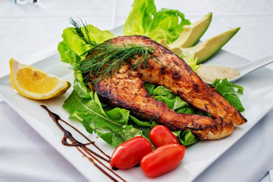 Grilled salmon with avocado, tomatoes and lemon
