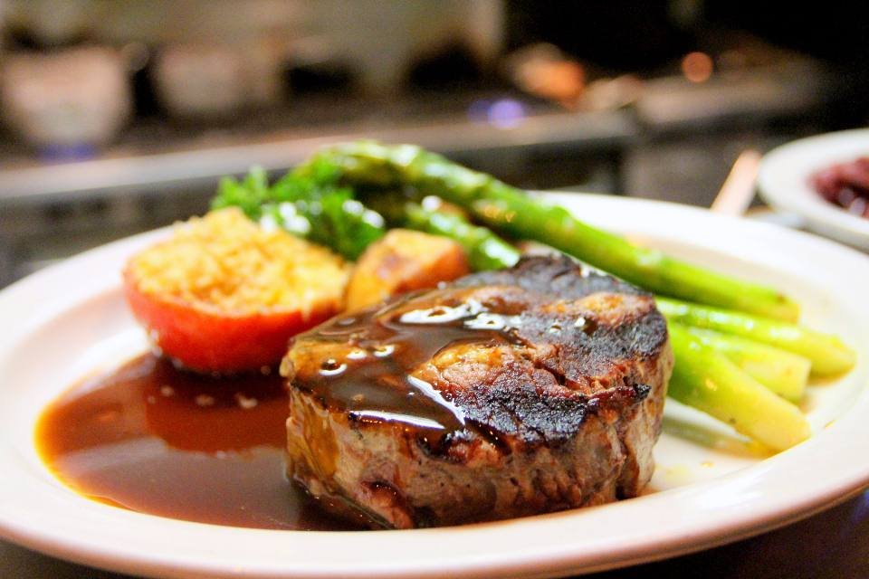 A seared steak with sauce and asparagus
